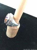 Angled side view of sterling silver men's ring on a ring mandrel showing large topaz gemstone and rope detailing.