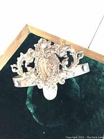 Close-up front view of Victorian copper tiara showing detailed central woman figure and floral scrollwork.