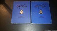 Both blue hardcover Olympia 1936 photo albums side by side, showing front covers with gold emblems and black lettering