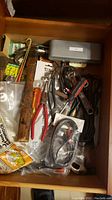 Drawer with assorted hand tools, cables, measuring tool, and miscellaneous items