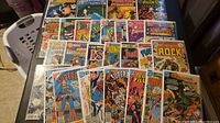 Full view of all comics laid out showing front covers, their bold colors, and variety of titles.