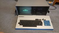 Front of Kaypro II showing built-in CRT monitor active, dual floppy drives and detachable keyboard