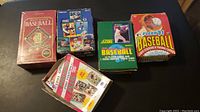 Five boxes of trading cards, including unopened and opened; 1992 Donruss Baseball, 1991 Score Baseball, 1991 Pacific Football packs, 1991 Fleer Football and Baseball boxes.