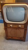 Full view of the vintage General Electric console TV with wooden cabinet and CRT screen.