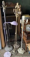 Four vintage floor lamps in various states of wear; includes purple gooseneck and three metal candelabra style lamps.