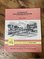 Front cover of the July 1964 Bell Telephone Book showing the name Lindsay Peterborough and an illustration of a park and a house.