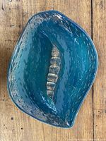 Top-down view of green and gold leaf-shaped ashtray showing the full item shape and color.