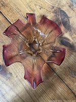 Top view of the pink and gold glass dish showing its unique ruffled edges and flowing form with translucent glass and swirl pattern.