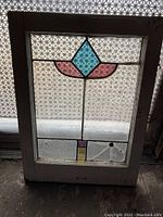 Full view of vintage stained glass window with textured clear glass and colored pieces.