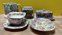 Front view of chintz ceramic set with various pieces showing floral pattern and shapes.