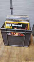 Plastic milk crate filled with assorted vinyl records; front record is Neil Diamond 'Gold' album