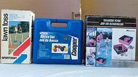 Photo showing three unopened boxed outdoor summer game sets: Sportcraft Lawn Toss, Cooper Bocce Set, and MD Sports Washer Toss