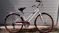 Full side view of the white and red 26" women's bicycle showing frame, wheels, and chain guard.