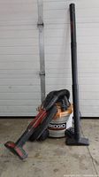 Front view of Ridgid 6 gallon wet/dry vacuum with hose, extension wand, and floor nozzle attachment.
