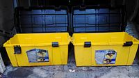 Two yellow plastic tool boxes with open lids, showing the interior and black snap latches on the front. Bright yellow exterior is heavy plastic, designed to be waterproof and durable.