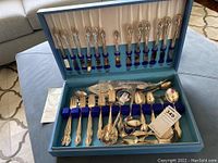 Full set of silver plated flatware including forks, knives, spoons, and serving pieces in original blue case with velvet inserts.