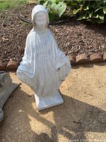 Full-length view of concrete religious statue on ground