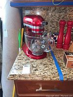 Stand mixer with glass bowl and salt/pepper mills on countertop