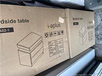 Two sealed cardboard boxes labeled i-aplus A02-1 bedside table