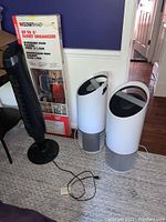 Photo showing two Purezone air purifiers, black tower fan, and boxed ClosetMaid closet organizer