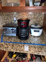 Photo showing stainless steel toaster, Mr. Coffee coffee maker, and white rice cooker on granite countertop
