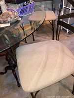 Close-up photo of the beige upholstered chair seat with visible stains and textured fabric pattern.