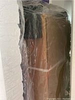 Unassembled TV stand parts in original packaging wrapped in plastic