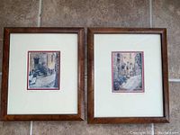 Framed pair of two artist's proof prints by Richard Quataert showing French village street scenes.