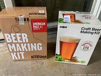 Two beer making kit boxes side by side on floor; Brooklyn BrewShop and MrBeer brand visible with product information.