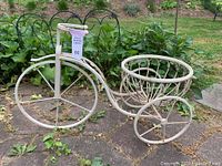 Full view of the metal bicycle planter showing the front large wheel and back basket planter section.