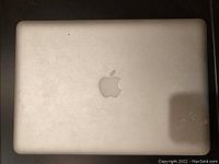 Top view of closed MacBook Pro A1278 silver aluminum laptop with visible Apple logo on lid.