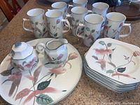 Full set arranged on a counter showing all pieces: 8 octagonal plates, 8 mugs, sugar bowl, creamer, serving platter.