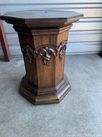 Full view of the octagonal wood pillar side table showing carved details on the sides and shape of the base.