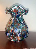 Front view of the vase showing the colorful splatter pattern and ruffled top edge.