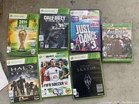 All seven game discs shown together on floor, case art visible.