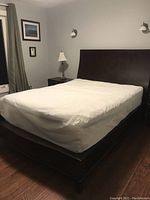 Queen size bed frame with chocolate dark brown headboard and footboard in bedroom setting