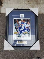 Front view of framed hockey photo showing Toronto Maple Leafs players and autograph.