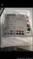 White fabric foldable wing back chair cover in package with label showing illustration of chair and color options