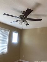 Brown Hampton Bay ceiling fan installed on ceiling with light fixture and five blades.