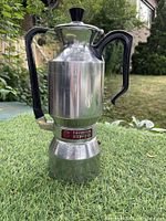 Full view of the assembled aluminum espresso maker with black Bakelite handle and knob, showing its overall condition and branding.