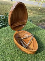 Open view showing the interior of the walnut-shaped wooden nut bowl with the metal nutcracker and nut picks inside.