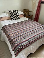 Blanket laid out on a double mattress, showing full size and color pattern.