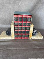 Front view of four philosophy books in slipcase between marble bookends.