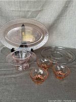 Overview of all items - clear Arcoroc platter on stand, three small pink bowls, pink rolled console vase, glass pedestal cake stand with silver overlay tray.