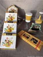 Photo showing vintage letter holder with harvest illustrations and compartments for organization, plus Androck jar chopper and Federal Housewares nut chopper with hand crank.
