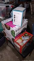 Stack of boxed items including Instant Pot Nova, Maverick turning slicer, and electric heater packaging.