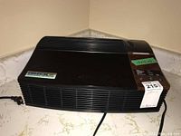 Front angled view of Oreck XL air purifier showing black body with vents and control panel.