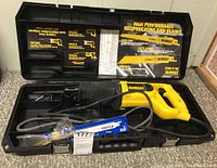 DeWalt DW303 reciprocating saw in black plastic carry case with molded compartments, showing saw and packaging/label inside lid