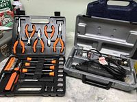 Black hand tool kit including pliers, screwdrivers, bits and sockets organized in a black plastic carry case.