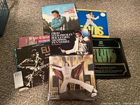 Overview photo showing multiple Elvis Presley LP vinyl albums, including double albums and the collectors edition set, arranged on floor.